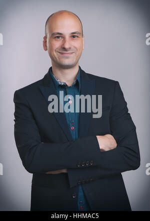 Lächeln auf den Lippen schön Geschäftsmann im Anzug mit seinen Armen gefaltet Stockfoto