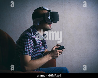 Mann Spiel Computer zu Hause in virtuelle Brille Stockfoto