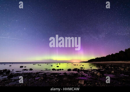 Intensive Nordlichter (Aurora Borealis) über Ostsee. Felsiger Strand Stockfoto