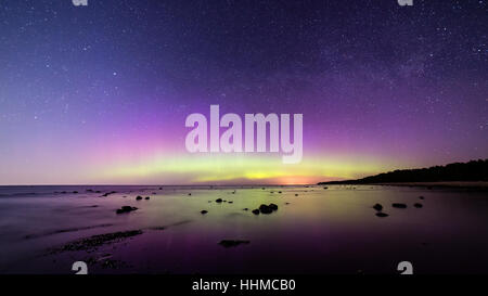 Intensive Nordlichter (Aurora Borealis) über Ostsee. Felsiger Strand Stockfoto