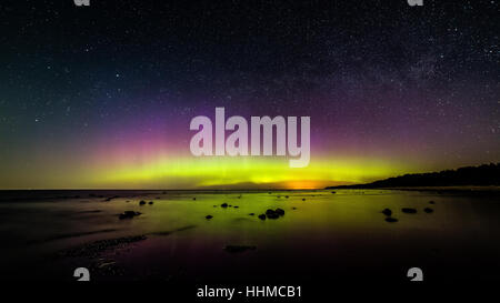 Intensive Nordlichter (Aurora Borealis) über Ostsee. Felsiger Strand Stockfoto