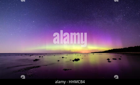 Intensive Nordlichter (Aurora Borealis) über Ostsee. Felsiger Strand Stockfoto