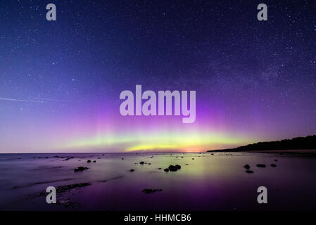 Intensive Nordlichter (Aurora Borealis) über Ostsee. Felsiger Strand Stockfoto