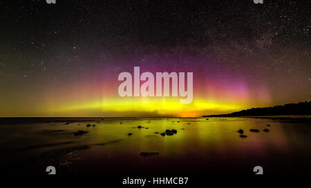 Intensive Nordlichter (Aurora Borealis) über Ostsee. Felsiger Strand Stockfoto