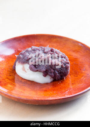 Japanische Küche, ein Reiskuchen mit süßen roten Bohnen paste auf die Holzplatte Stockfoto