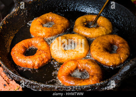 Donuts sind in einer Pfanne mit heißem Öl, Bandipur, Tanahun Bezirk, Nepal gebraten. Stockfoto