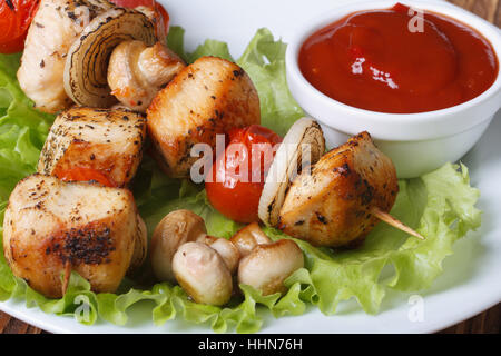 Hähnchenspieße auf Spieße mit Gemüse auf einem Teller mit Soße. horizontale. Makro Stockfoto