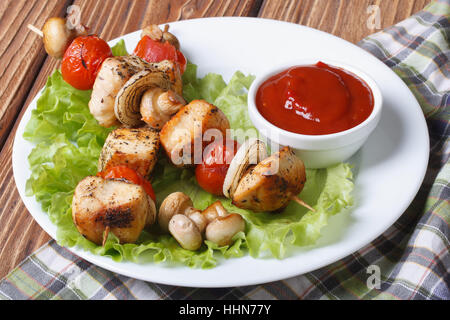 zwei gegrillte Hähnchen-Kebab mit Pilzen auf einem Teller mit Soße. horizontale. Close-up Stockfoto