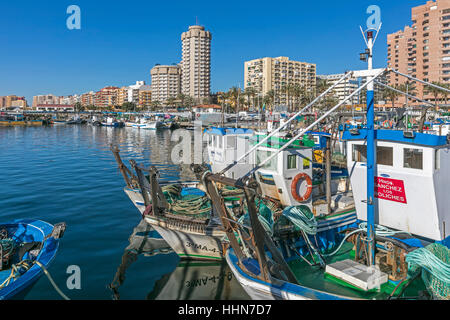 Fuengirola, Costa Del Sol, Provinz Malaga, Andalusien, Südspanien. Fischerboote im Hafen. Hotels und Wohnhäuser hinter. Stockfoto