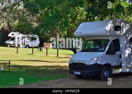 Wohnmobile auf dem Campingplatz Sugarloaf mit viel Grün und Annehmlichkeiten Braai (bbq) auf dem Familiengelände in St. Lucia, Kwazulu Natal, Südafrika Stockfoto