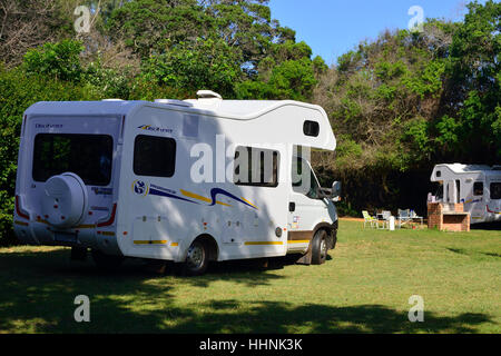 Wohnmobile auf dem Campingplatz Sugarloaf mit viel Grün und Annehmlichkeiten Braai (bbq) auf dem Familiengelände in St. Lucia, Kwazulu Natal, Südafrika Stockfoto