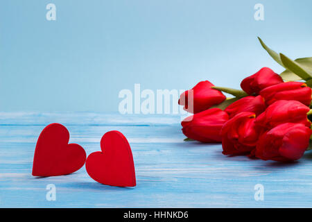 Rote Tulpen auf blauen Holztisch. Draufsicht mit Textfreiraum Stockfoto