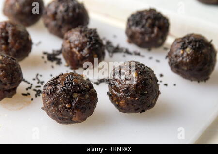 schwarze Schokolade Kugeln auf einem weißen Tisch Stockfoto