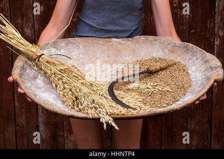 Kaukasische Frau mit Tablett mit Weizen und Sichel Stockfoto