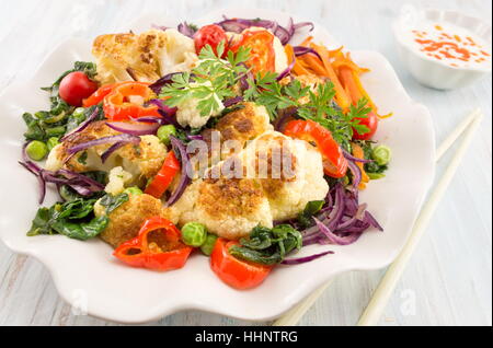 Gebratener Blumenkohl und Mischgemüse mit Stäbchen Stockfoto