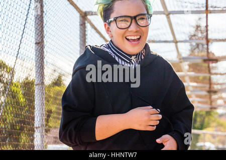 Androgyne asiatische Frau lachend auf Steg Stockfoto