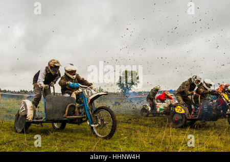 Kaukasische Rennfahrer auf Motorrädern mit Seitenwagen Spritzen Schmutz Stockfoto