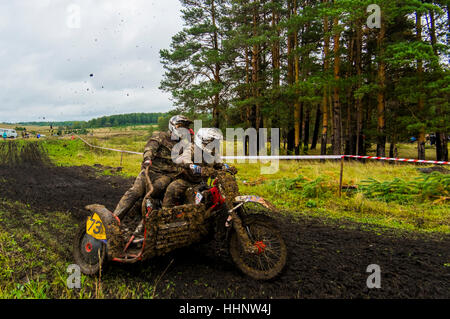 Kaukasische Rennfahrer auf dem Motorrad mit Beiwagen Spritzen Schmutz Stockfoto