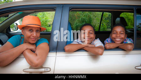 Porträt der Mutter und zwei Söhne, stützte sich auf Autoscheiben Stockfoto