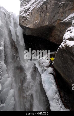 Fotograf aus festen Kletterseilen sichern sich am Rande des teilweise gefrorenen Wasserfall zu Foto Kletterer auf dem Eis ausgesetzt Stockfoto