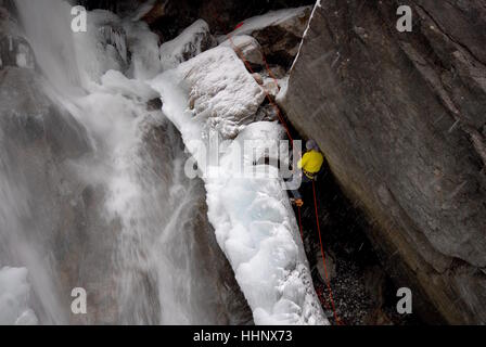 Fotograf aus Kletterseilen sichern sich im Ort am Rand des teilweise gefrorenen Wasserfall zu Foto Sport Eiskletterer ausgesetzt Stockfoto