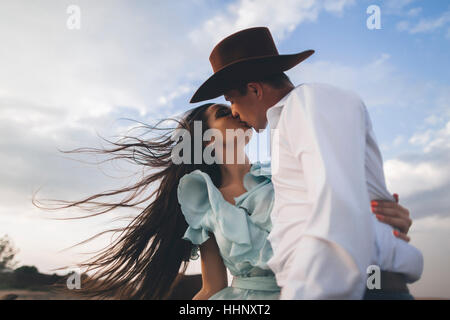 Kaukasische Cowboy küssen Frau im wind Stockfoto