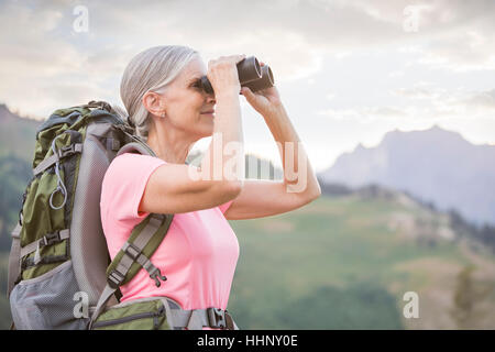 Kaukasische Frau Wandern am Berg mit dem Fernglas Stockfoto