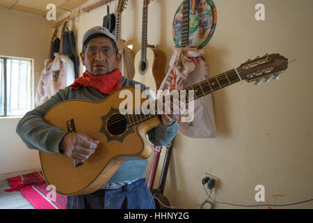 22. Juli 2016 San Bartolome, Ecuador: Gitarrenbauer Mann stehend mit einer fertigen Konzertgitarre in seinem Geschäft Stockfoto