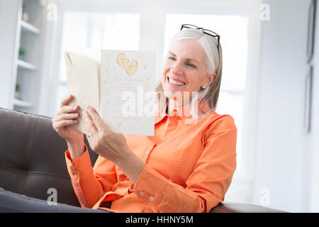 Kaukasischen Frauen lesen Grußkarte Stockfoto