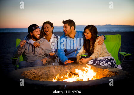 Paar am Strand von Feuerstelle entspannen Stockfoto