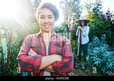 Lächelnde Frauen posieren im Garten Stockfoto