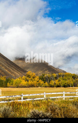 Zaun und Berg unter Wolken Stockfoto