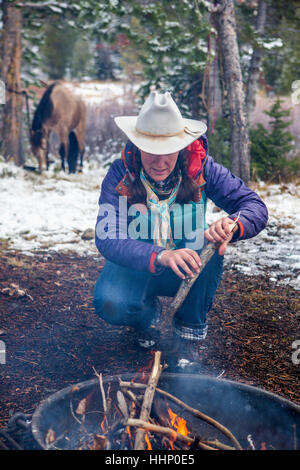 Kaukasische Frau ins Lagerfeuer Holz Stockfoto