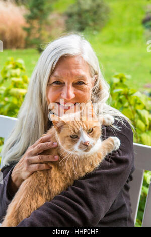 Porträt des Lächelns kaukasischen Frau Holding Katze Stockfoto