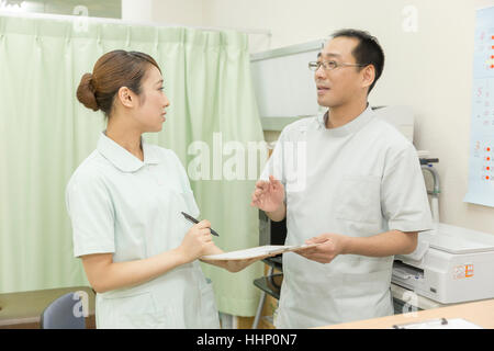 Arzt und Krankenschwester diskutieren Patientenakte Stockfoto