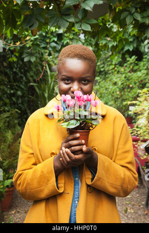 Porträt von lächelnden schwarze Frau Blumen riechen Stockfoto