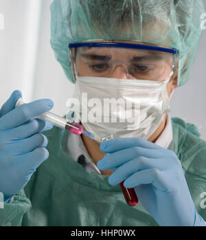 Kaukasische Wissenschaftler halten, Spritze und Reagenzglas Stockfoto