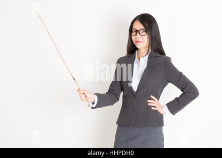 Asiatische weibliche Lehrer Hand hält einen Stock in Klasse Lektion auf einfarbigen Hintergrund stehend. Stockfoto