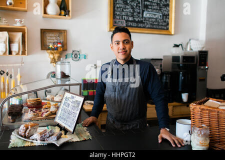 Junge spanische Barista stehen am Café-Schalter Stockfoto