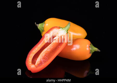 Rote, gelbe und orange Paprika auf schwarz Stockfoto