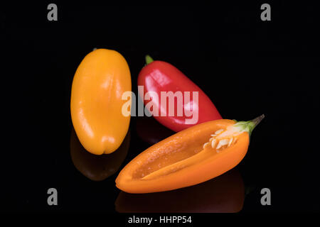 Rote, gelbe und orange Paprika auf schwarz Stockfoto