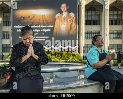 Bangkok, Thailand. 20. Januar 2017. Frauen beten vor Porträt zu Ehren des verstorbenen Königs auf der Plaza vor dem Rathaus Bangkoks. Hunderte von städtischen Arbeiter und Beamte gemacht Verdienst indem beten und Almosen zu 89 buddhistische Mönche Freitag anlässlich 100 Tage der Trauer nach dem Tod des verehrten Bhumibol Adulyadej, der spät König von Thailand. Die Bedeutung von 89 Mönche ist, dass der König, der am 13. Oktober 2016, starb wenige Wochen vor seinem 89. Geburtstag war. Bildnachweis: Jack Kurtz/ZUMA Draht/Alamy Live-Nachrichten Stockfoto