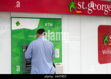 Mann mit einem St George bank Geldautomat ATM in Sydney, Australien. St George ist im Besitz von Westpac Bank. Stockfoto