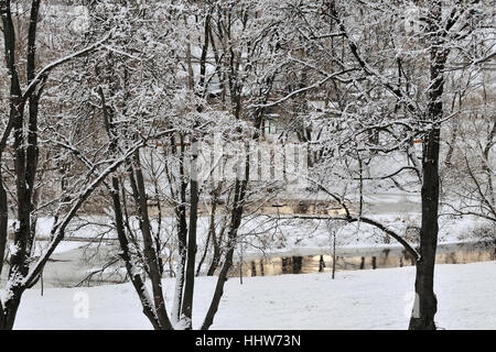 Bäume mit Schnee bedeckt spiegeln sich in den ruhigen Gewässern des Tiefland River, Pakhra River, Podolsk, Moscow Region, Russland Stockfoto