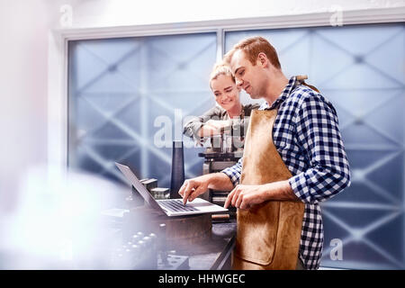 Juweliere mit Ausrüstung und Laptop in Werkstatt Stockfoto