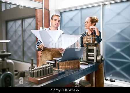 Juweliere, die Baupläne am Laptop in Werkstatt anzeigen Stockfoto