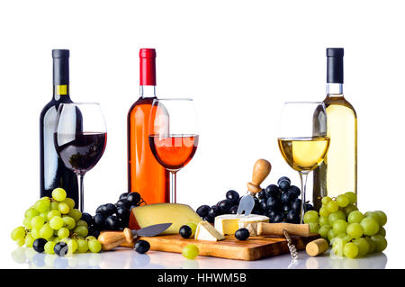 Drei Gläser und Flaschen Wein mit roten und weißen Trauben und Käse auf Schneidbrett aus Holz, alle auf weißem Hintergrund Stockfoto