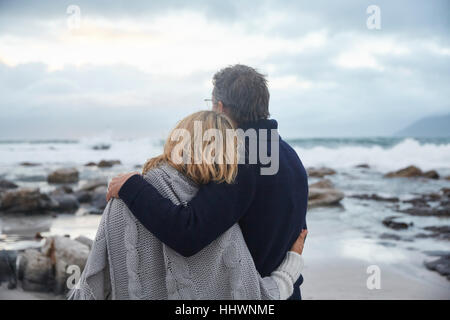 Heitere paar umarmt am Winter-Strand Stockfoto