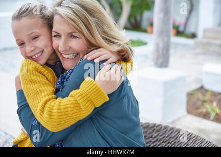 Begeisterte Großmutter und Enkelin umarmt auf Terrasse Stockfoto