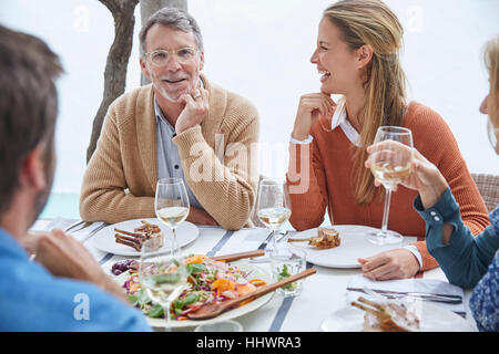 Paare, Mittagessen am Patio Tisch essen und trinken Weißwein Stockfoto